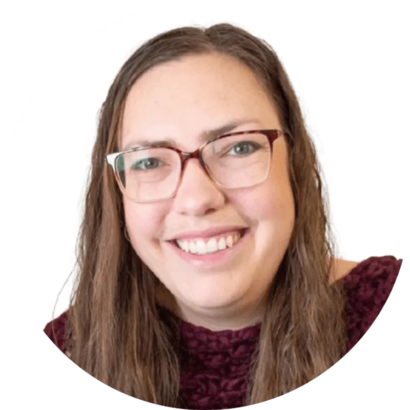 Smiling person with glasses and long hair.