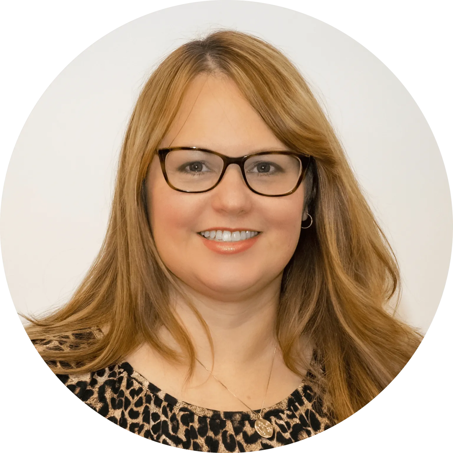 Smiling woman with glasses and leopard print.