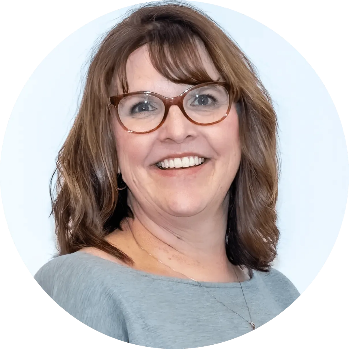 Smiling woman with glasses and brown hair.