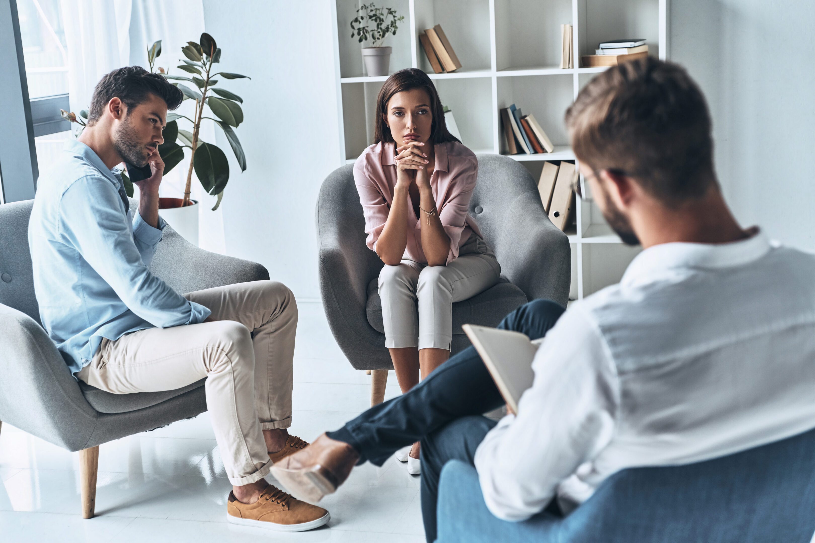 Almost divorced. Young married couple talking while sitting on the therapy session with psychologist